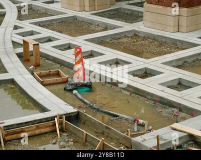 En construction projet de construction inachevé avec béton et bois. Cônes orange et tuyau au sol. Design carré en béton d'architecture Banque D'Images