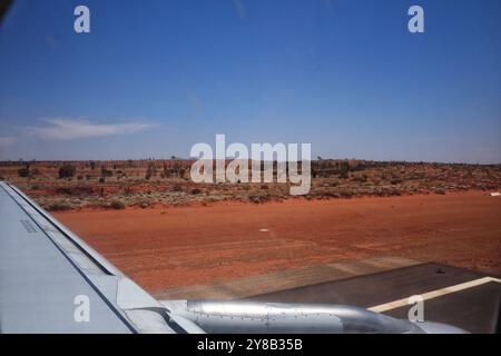 Décollage de l'aéroport d'Ayers Rock (Connellan Airport) à Yulara, Uluru, Australie centrale, vue sur la piste et le désert rouge Banque D'Images