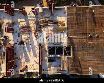Une vidéo de drone montrant une vue de haut en bas d'un chantier de construction. L'image capture les fondations, les échafaudages et les matériaux du bâtiment Banque D'Images