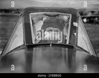 L'officier de vol Frank Murphy du 486e Escadron dans le cockpit d'un Hawker Typhoon, un chasseur-bombardier britannique monoplace, destiné à remplacer l'intercepteur à moyenne-haute altitude du Hawker Hurricane. Mais lorsque la Luftwaffe a mis en service le nouveau Focke-Wulf Fw 190 en 1941, le Typhoon était le seul chasseur de la RAF capable de l'attraper à basse altitude ; en conséquence, il a obtenu un nouveau rôle d'intercepteur à basse altitude. Il est devenu un intrus nocturne et un chasseur à longue portée et, avec un armement accru, est devenu l'un des avions d'attaque au sol les plus réussis de la seconde Guerre mondiale. Banque D'Images