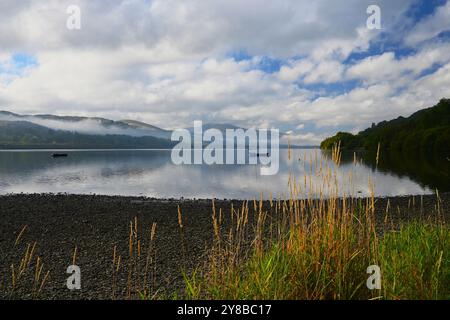 Bala Lake (Llyn Tegid) dans le parc national d'Eryri (Snowdonia) sur un matin brumeux et d'humeur changeante, des reflets et de la brume roulante avec Yr Aran à 3 miles de distance. Banque D'Images