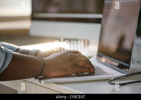 Mains masculines méconnaissables tapant sur le clavier noir Banque D'Images