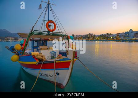 Bateau de pêche grec, vue au crépuscule d'un bateau de pêche grec coloré amarré dans la baie de Sitia sur la côte nord-est de la Crète, Grèce. Banque D'Images