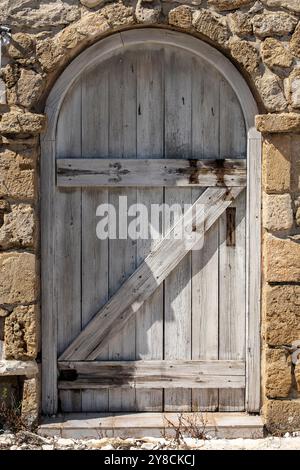 porte en bois antique forte et sécurisée en chêne massif épais, porte extérieure robuste sur le vieux château de maison seigneuriale situé dans un mur de pierre lourd Banque D'Images