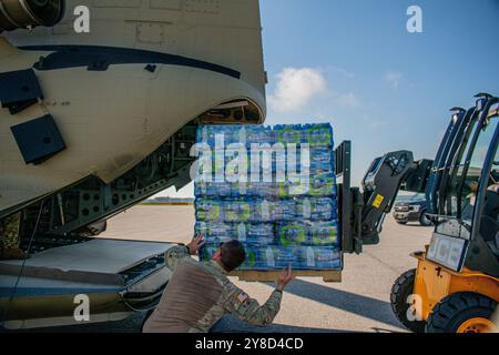 Macon, États-Unis. 30 septembre 2024. Des soldats de l'armée américaine, affectés au 78th Aviation Troop Command, de la Garde nationale de Géorgie, chargent des palettes d'eau dans un hélicoptère CH-47 Chinook pour les survivants de l'ouragan Helene à l'aéroport régional de Middle Georgia, le 30 septembre 2024, à Macon, en Géorgie. Crédit : SPC Katlynn Pickle/US Army/Alamy Live News Banque D'Images