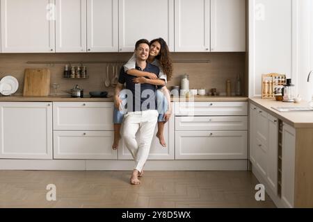 Heureux jeune couple marié posant pour un portrait à domicile Banque D'Images