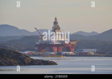 Plate-forme pétrolière dans un paysage marin calme sur fond de montagne dans une lumière paisible, automne, Bergen, mer du Nord, Norvège, Europe Banque D'Images