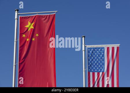 Les drapeaux chinois et américains flottent devant un ciel bleu clair Banque D'Images