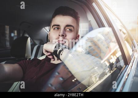 Profitez de la conduite. Image d'un jeune beau gars assis dans la voiture Banque D'Images