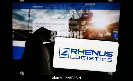 Allemagne. 23 septembre 2024. Dans cette illustration photo, une personne tient un téléphone portable avec le logo de la société de logistique allemande Rhenus se Co. KG devant la page Web de l'entreprise. Crédit : SOPA images Limited/Alamy Live News Banque D'Images