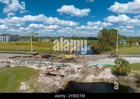 Construction de routes. Excavatrice réparant le pont détruit après que l'ouragan a inondé l'asphalte en Floride. Matériel de construction sur la route Banque D'Images