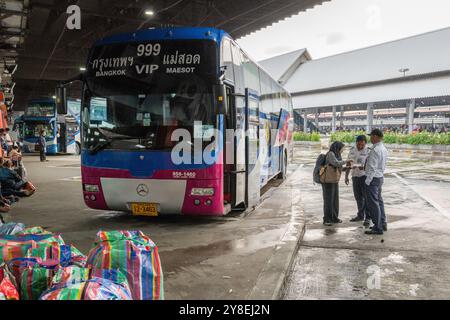 Une vue d'un double étage à une heure de départ avec des bagages à l'extérieur, et un passager discutant avec les chauffeurs, au terminal de bus Mo Chit, à Bangkok. Le 1er octobre 2024, un tragique accident de bus à impériale à Bangkok a coûté la vie à plusieurs étudiants. L'incident a mis en évidence des problèmes de sécurité liés aux défauts de construction, à l'insuffisance des contrôles de sécurité et à l'adaptation des réservoirs de gaz naturel pour ces autobus souvent fabriqués par des entreprises locales. Les bus à impériale, couramment utilisés pour les voyages longue distance et abordables, sont souvent la seule option pour les habitants thaïlandais rentrant chez eux chaque semaine, également par les voyagistes touristiques Banque D'Images