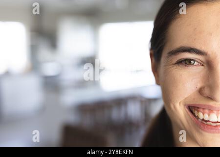 Image recadrée de la belle jeune femme caucasienne souriante avec l'œil brun à la maison, espace de copie Banque D'Images