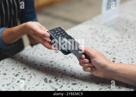 Milieu de section d'une femme caucasienne faisant le paiement sans contact au comptoir au gymnase Banque D'Images
