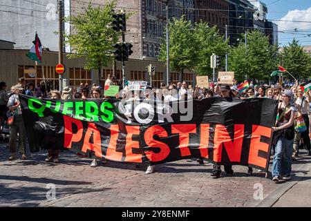 Queers pour la Palestine. Activistes pro-palestiniens avec une grande bannière au défilé Helsinki Pride 2024 sur Mannerheimintie à Helsinki, Finlande. Banque D'Images