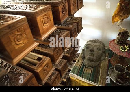 Une sculpture, un ensemble de balinais offrant du matériel et des boîtes en bois contenant de vieux manuscrits en feuilles de palmier au musée Gedong Kirtya à Singaraja, Bali. Banque D'Images