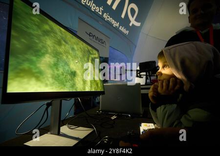 Varsovie. 4 octobre 2024. Un garçon regarde un simulateur de vol sur un moniteur lors de la 13ème nuit à l'Institut de l'aviation de Varsovie, Pologne le 4 octobre 2024. Cet événement annuel, organisé par l'Institut de l'aviation de Varsovie, est l'une des plus grandes activités éducatives nocturnes dans le pays, visant à promouvoir les connaissances et les carrières dans l'aviation et l'ingénierie. Crédit : Jaap Arriens/Xinhua/Alamy Live News Banque D'Images