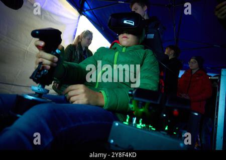 Varsovie. 4 octobre 2024. Un adolescent joue un simulateur d'avion de chasse lors de la 13ème nuit à l'Institut de l'aviation de Varsovie, Pologne le 4 octobre 2024. Cet événement annuel, organisé par l'Institut de l'aviation de Varsovie, est l'une des plus grandes activités éducatives nocturnes dans le pays, visant à promouvoir les connaissances et les carrières dans l'aviation et l'ingénierie. Crédit : Jaap Arriens/Xinhua/Alamy Live News Banque D'Images