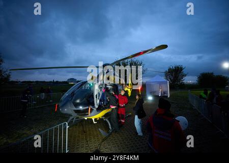 Varsovie. 4 octobre 2024. Les visiteurs observent un hélicoptère médical lors de la 13ème nuit à l'Institut de l'aviation de Varsovie, Pologne, le 4 octobre 2024. Cet événement annuel, organisé par l'Institut de l'aviation de Varsovie, est l'une des plus grandes activités éducatives nocturnes dans le pays, visant à promouvoir les connaissances et les carrières dans l'aviation et l'ingénierie. Crédit : Jaap Arriens/Xinhua/Alamy Live News Banque D'Images