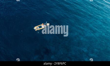 Femme nage sur kayak dans la mer bleue. Vue drone Banque D'Images