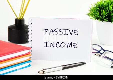Concept d'investissement et de financement. Le concept du business de l'information. Le texte du REVENU PASSIF est écrit sur une feuille blanche de bloc-notes. Banque D'Images