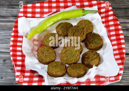 Piment vert et boules de falafel traditionnelles égyptiennes frites servies dans une assiette, burger vert, fait de pois chiches moulus et de fèves, frites Banque D'Images