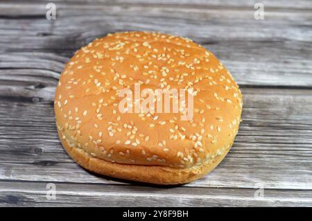 Hamburger rond à la main hamburger petit pain cuit et couvert de graines de sésame, le pain est un type de pain, généralement rempli de garnitures salées, fait fr Banque D'Images