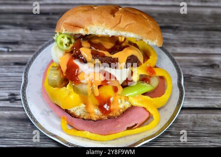 Hamburger de bœuf frit avec tranches de concombres marinés, oignons, viande de déjeuner coupée, ketchup et sauce burger, morceaux de pain burger, restauration rapide, Junk Banque D'Images