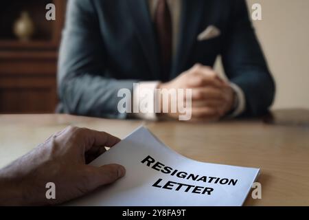 Homme d'affaires recevant la lettre de démission au milieu de la Grande démission. Grand concept de démission Banque D'Images