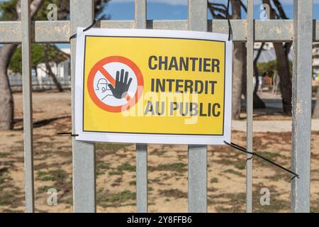 Un panneau d'avertissement d'interdiction d'entrer sur une clôture métallique écrit en français. Banque D'Images