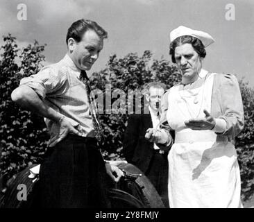 JOHN MILLS et le réalisateur / Star WILL HAY (en uniforme d'infirmière) sur le lieu de tournage candide lors du tournage du MOUTON NOIR DE WHITEHALL 1942 réalisateurs BASIL DEARDEN et WILL HAY histoire originale / scénario Angus MacPhail et John Dighton producteur Michael balcon Ealing Studios / United Artists Banque D'Images