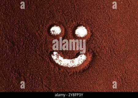 symbole de visage heureux, peint dans la poudre de café. Banque D'Images