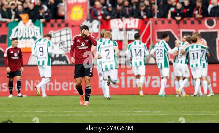 Nuernberg, Deutschland. 05 octobre 2024. IM Bild : IM Hintergund bejubeln die Spieler von Preussen Muenster das 2:1, vorne Stefanos TZIMAS (1.FC Nuernberg, 9) Enttaeuschung, niedergeschlagen, deprimiert, frust, enttaeuscht, enttaeuscht schauend, déçue. 05.10.2024, Fussball, 2. Bundesliga, 1. FC Nuernberg - SC Preussen Muenster, GER, Nuernberg, Max-Morlock-Stadion, DFL LA RÉGLEMENTATION INTERDIT TOUTE UTILISATION DE PHOTOGRAPHIES COMME SÉQUENCES D'IMAGES ET/OU QUASI-VIDÉO. Crédit : dpa/Alamy Live News Banque D'Images