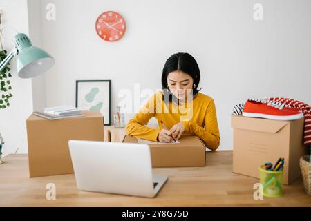 Femme freelance de petite entreprise préparant des paquets pour la livraison au client Banque D'Images