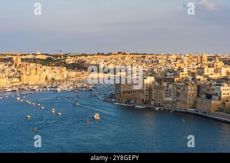 Vue des trois villes de Malte à travers le Grand Port à la Valette au coucher du soleil, Malte Banque D'Images