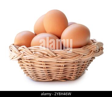 Groupe d'oeufs de poule brun frais dans la pile dans le panier en osier est isolé sur fond blanc avec chemin de découpage. Banque D'Images