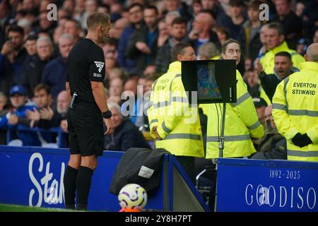 L'arbitre Craig Pawson consulte le VAR côté terrain pour une éventuelle pénalité qui est donnée à Newcastle pour une faute de James Tarkowski d'Everton (non représenté) lors du match de premier League à Goodison Park, Liverpool. Date de la photo : samedi 5 octobre 2024. Banque D'Images