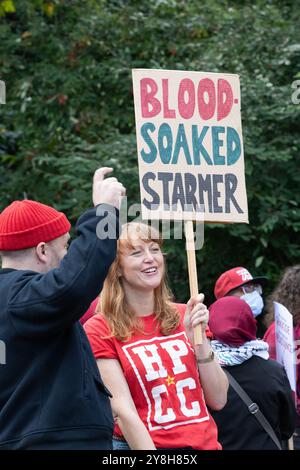 Londres, Royaume-Uni. 5 octobre 2024. Une femme tient une pancarte déclarant que le premier ministre "Starmer trempé dans le sang" alors que les partisans de la Palestine participent à la 20ème Marche nationale pour la Palestine, marquant un an depuis qu'Israël a lancé sa guerre contre Gaza et la Cisjordanie occupée suite aux attaques des militants du Hamas. Les activistes ont exigé que le Royaume-Uni cesse d'armer Israël, pour un cessez-le-feu immédiat et la fin de la dernière guerre d'Israël contre le Liban. Crédit : Ron Fassbender/Alamy Live News Banque D'Images