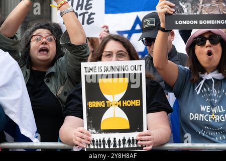 Londres, Royaume-Uni. 5 octobre 2024. Un petit groupe de contre-manifestants pro-israéliens regarde des dizaines de milliers de sympathisants palestiniens participer à la 20e Marche nationale pour la Palestine, marquant un an depuis qu’Israël a lancé sa guerre contre Gaza et la Cisjordanie occupée à la suite des attaques des militants du Hamas. Crédit : Ron Fassbender/Alamy Live News Banque D'Images