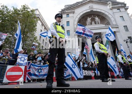 Londres, Royaume-Uni. 5 octobre 2024. Les policiers et les contre-manifestants pro-israéliens regardent les partisans de la Palestine marcher pendant la 20ème Marche nationale pour la Palestine, marquant un an depuis qu'Israël a lancé sa guerre contre Gaza et la Cisjordanie occupée. Les activistes ont exigé que le Royaume-Uni cesse d'armer Israël, pour un cessez-le-feu immédiat et la fin de la dernière guerre d'Israël contre le Liban. Crédit : Ron Fassbender/Alamy Live News Banque D'Images