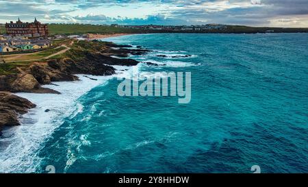 Une vue panoramique sur la côte avec des falaises rocheuses et des vagues turquoises qui s'écrasent contre le rivage. En arrière-plan, une plage de sable s'étend le long des coas Banque D'Images