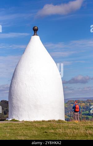 Homme marchant à dos vers White Nancy, un homme a fait un point de repère sur le sentier Gritstone au sommet de Kerridge Hill, surplombant Bollington, Cheshire Banque D'Images