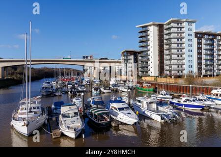 Bateaux amarrés dans la marina avec des aparments derrière au point où la rivière Ely rejoint la baie, Cardiff Bay, pays de Galles, Royaume-Uni Banque D'Images