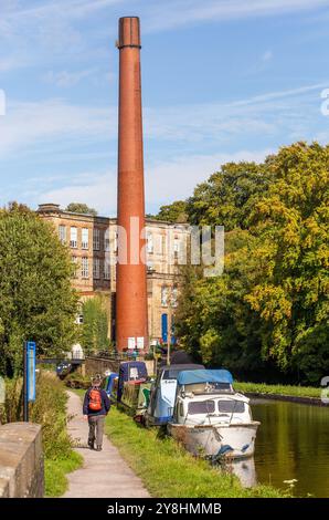 Bateaux amarrés sur le canal Macclesfield à Bollington près de Macclesfield Cheshire avec l'ancienne usine de coton Clarence Mill en vue Banque D'Images