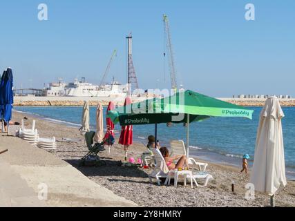 Tasucu, Turquie. 05 octobre 2024. La plage et le port de Ta?ucu, Turquie, 5 octobre 2024. La ville est en train de devenir une destination populaire pour des milliers de ressortissants libanais fuyant le port de Tripoli, au nord du Liban. Beaucoup de gens quittent le Liban par bateau car de nombreuses compagnies aériennes ne sont plus actives au Liban en raison de la guerre en cours. Ta?ucu est le principal terminal de ferry du sud de la Turquie. (Photo par Elisa Gestri/Sipa USA) crédit : Sipa USA/Alamy Live News Banque D'Images