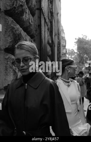 Caro Daur portant une veste-manteau longue en cuir rouge/marron/bordeaux et un pull à col tortue noir et des lunettes de soleil chez Hermès Paris Fashion week SS25 Banque D'Images