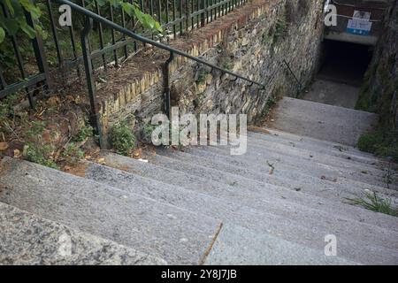 Escalier en pierre descendant qui mène à un passage souterrain dans une ville italienne Banque D'Images