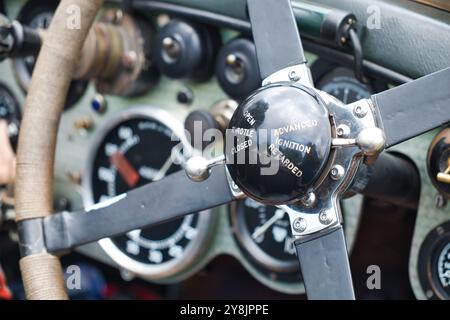 Gros plan d'un volant avec changement de vitesse manuel et vue de l'ancien tableau de bord d'une voiture de course vintage. Banque D'Images