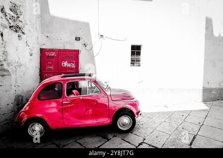 Rouge vieille Fiat 500 dans les allées d'Ostuni, la ville blanche. Banque D'Images