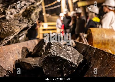 Focus sélectif sur le charbon anthracite sur une bande transporteuse avec un groupe défocalisé lors de la tournée de la mine de charbon de Lackawanna à McDade Park. Banque D'Images